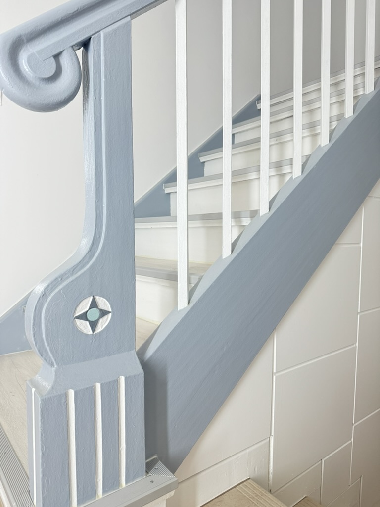 Maler in Mellrichstadt | Ihr Lieblings-Maler 3 Blau-weiß gestaltete Holztreppe mit ornamentalem Pfostendetail