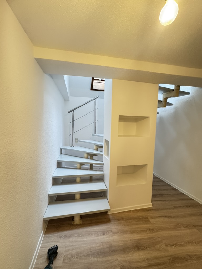 Maler in Bad Königshofen | Ihr Lieblings-Maler 4 Helles Treppenhaus mit offenem Treppenlauf und gegliederten Wandflächen